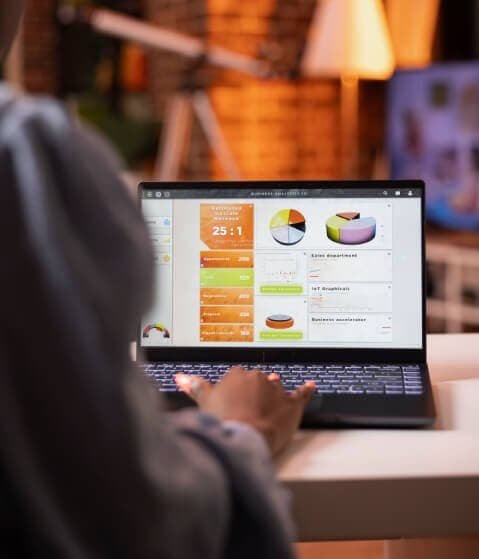 Person analyzing digital marketing data on a laptop for SEO optimization.